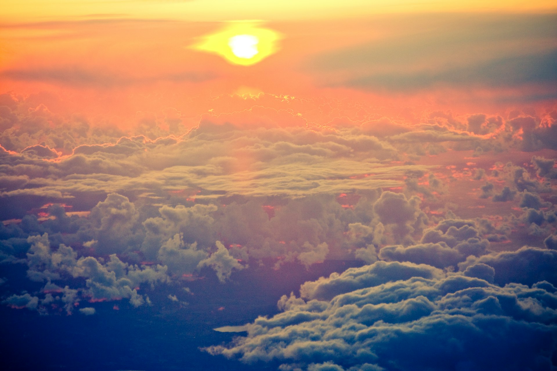 the sun is setting over the clouds in the sky